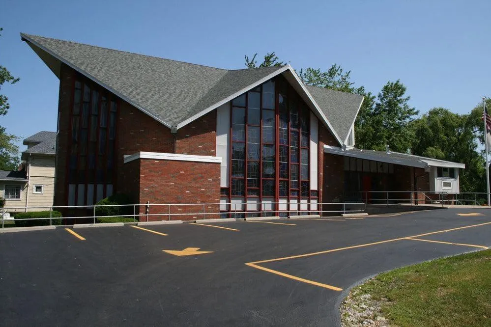 Tonawanda Free Methodist Church’s brick building, stained-glass windows, parking lot, and side entrance.